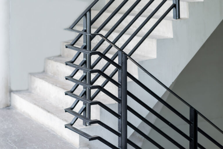 Stairway with black metallic banister in a new modern building a